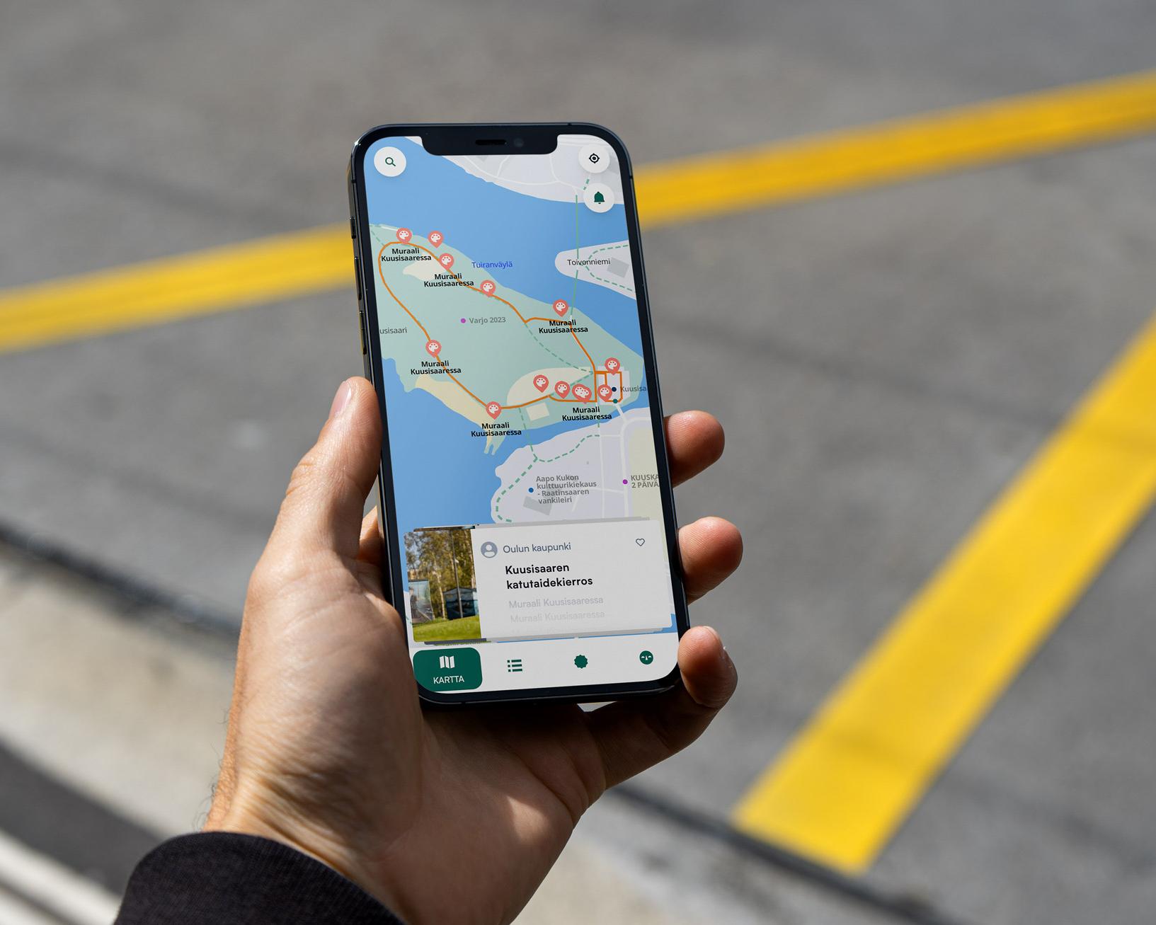 Hand holding a phone with an interactive island map showing a walking route and points of interest