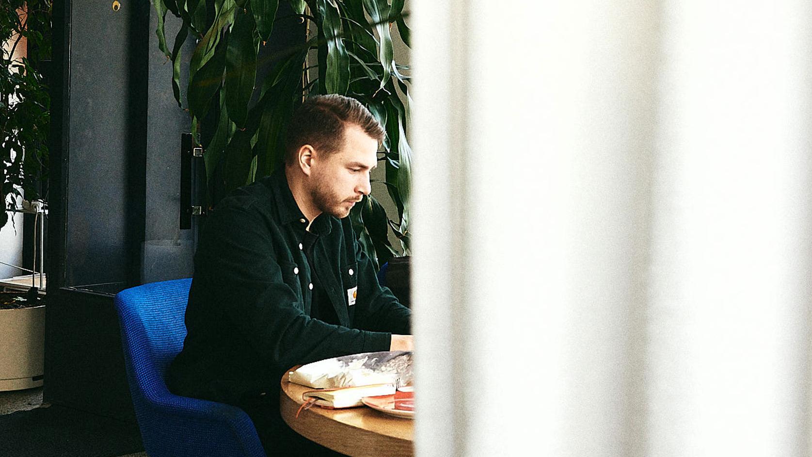 A man sitting on a table with his laptop